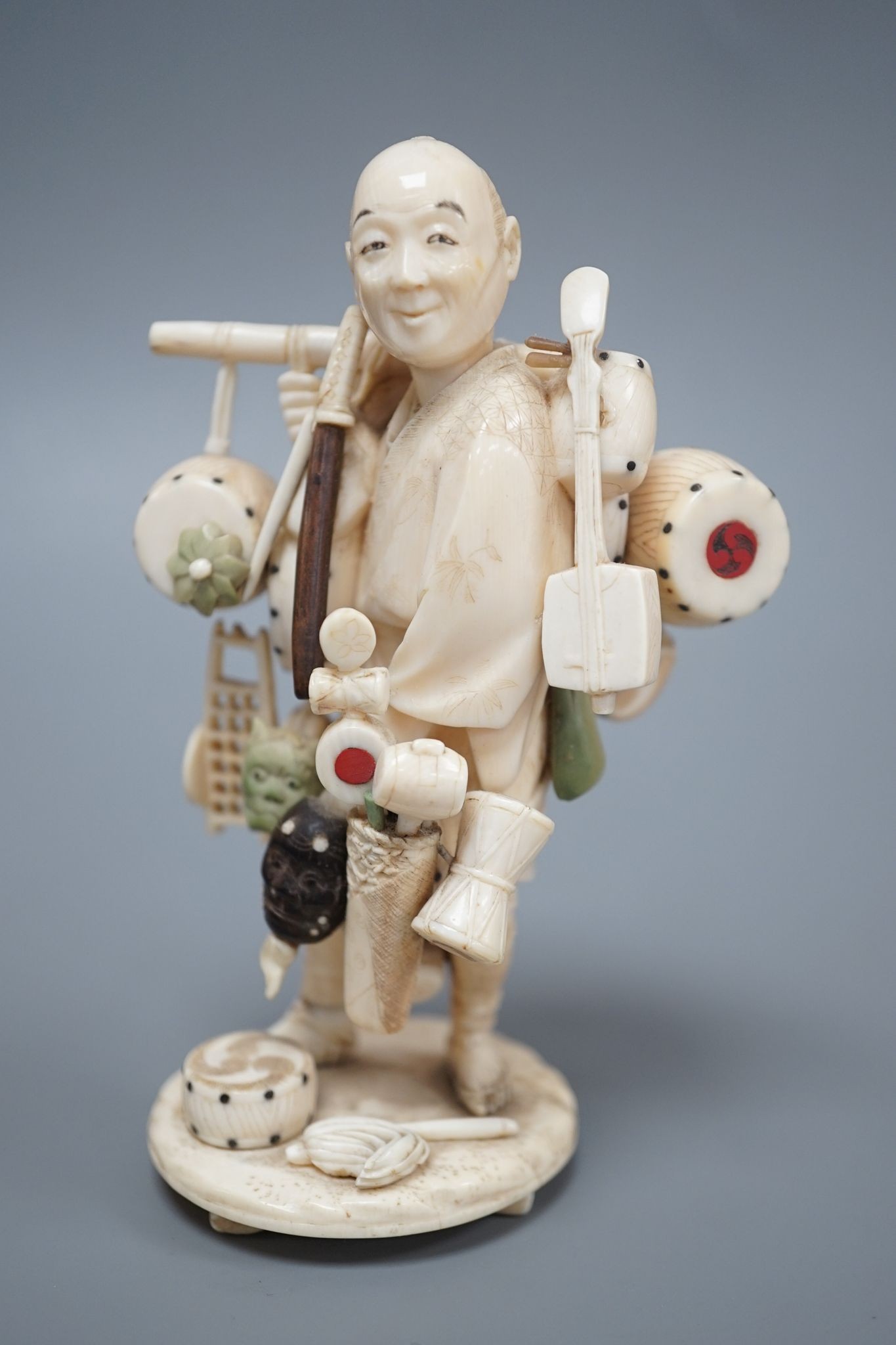 A Japanese ivory okimono of a street vendor, early 20th century 12cm